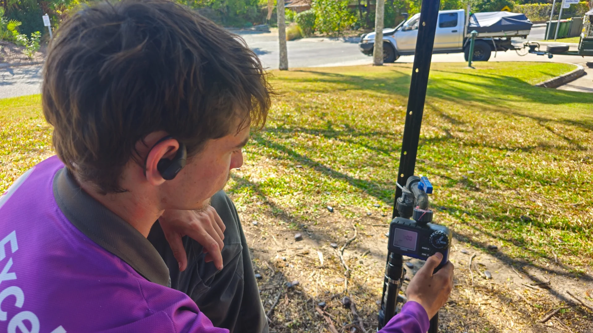 An Excel team member adjusting a garden irrigation timer