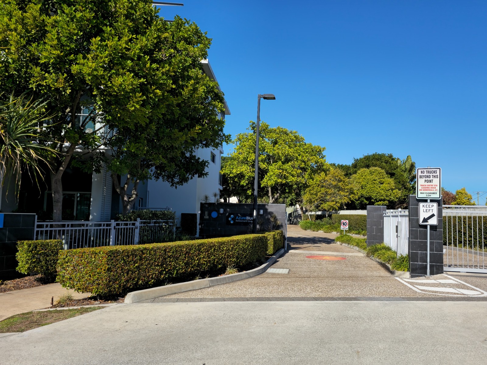 Trimmed hedges and trees at the Azure Blue retirement village entrance